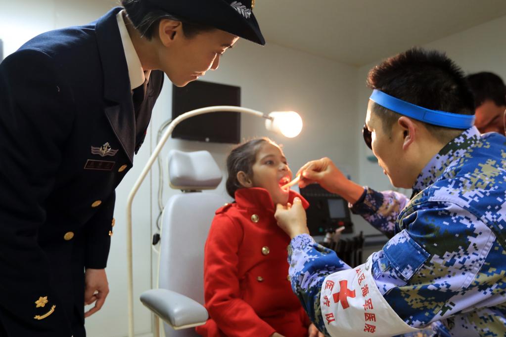 2019年12月9日，在中国海军“和平方舟”号医院船上，口腔科医生给时年9岁的沁做检查。